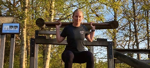 Kvinna som gör tyngdlyft på utegym.