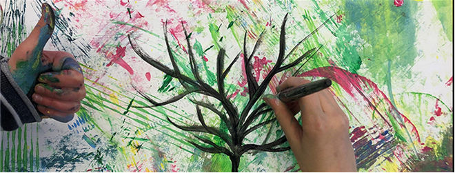 Händer som målar ett träd i akvarell