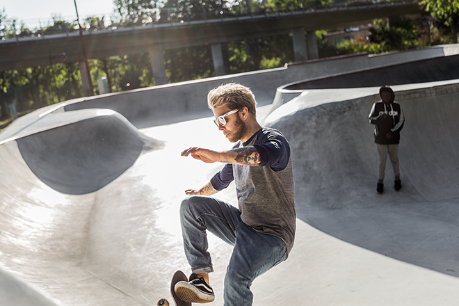 Kille åker skateboard i skatepoolen.