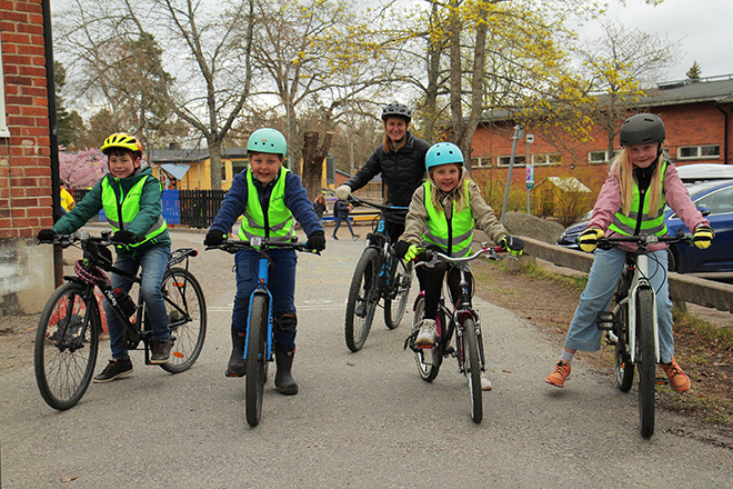 Fyra barn och en vuxen med sina cyklar.