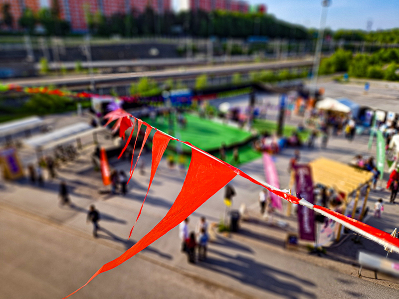 Vimplar i närbild, i bakgrunden syns en festival.
