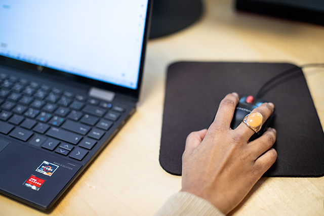 Laptop och en hand som navigerar
