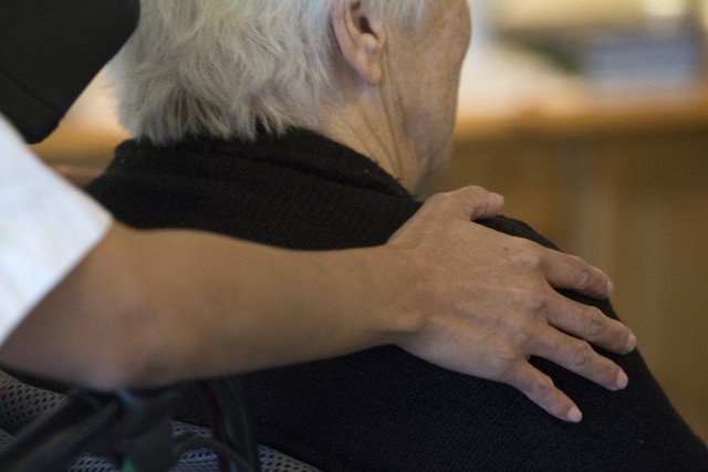 Två personer fotade bakifrån. En lägger en hand på axeln.