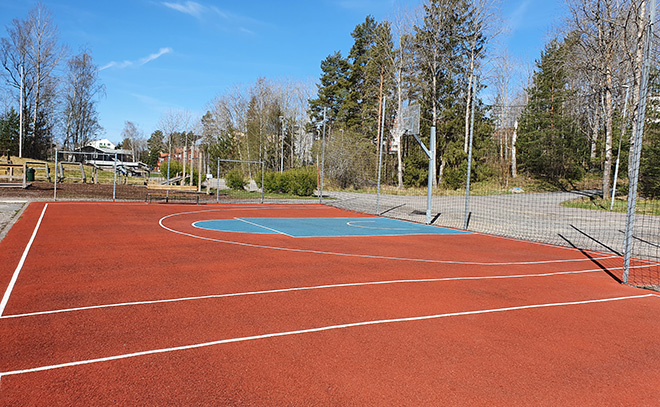 En mindre streetbasketplan med en basketkorg.