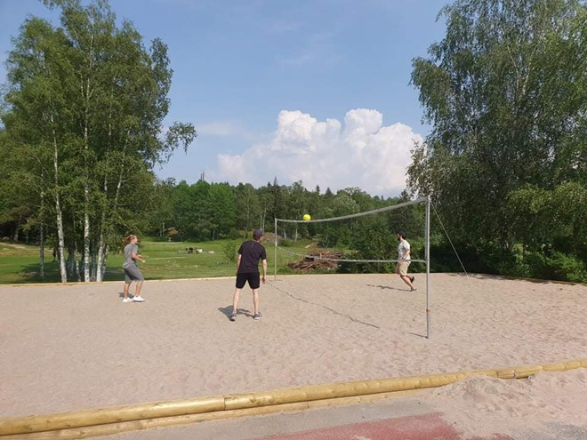 Tre personer som spelar beachvolleyboll.