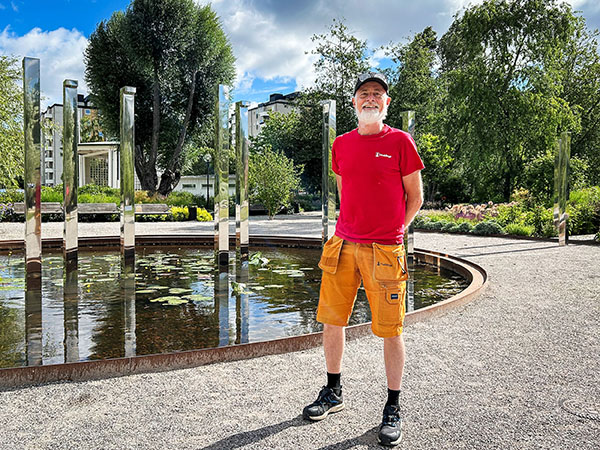 En man står i kortbyxor framför fontänen i Sjödalsparken